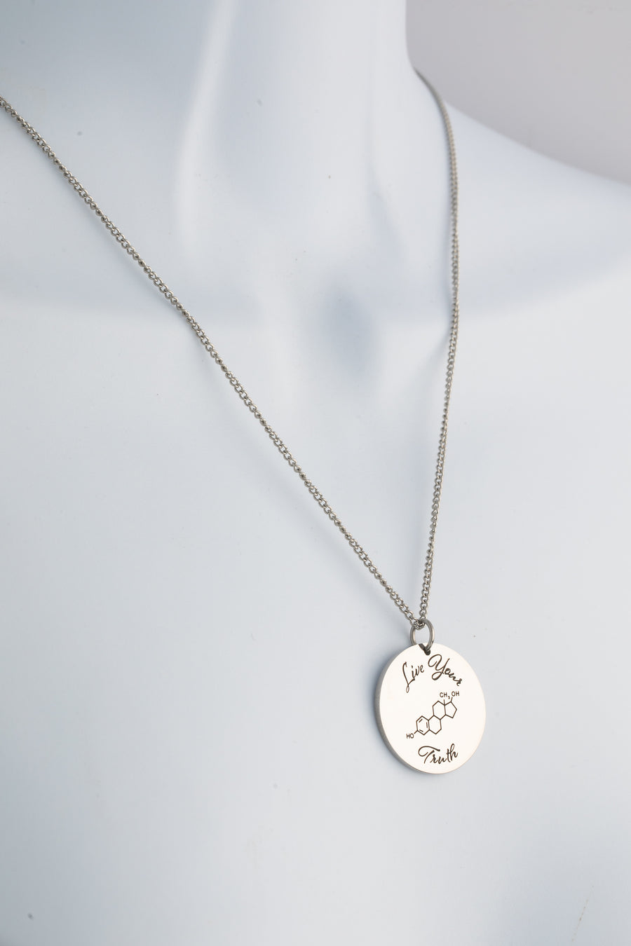 Live Your Truth Estrogen Pendant with engraved estrogen chemical symbol on a circular stainless steel disc — Outer Peace Gear